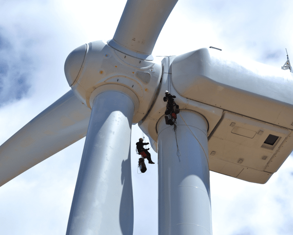 workers painting wind turbine